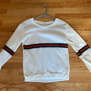 White sweater with green and red stripe.